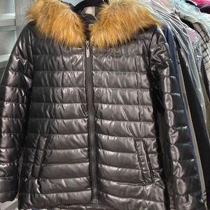 Shiny black winter puffer jacket with tan faux fur hood apres ski